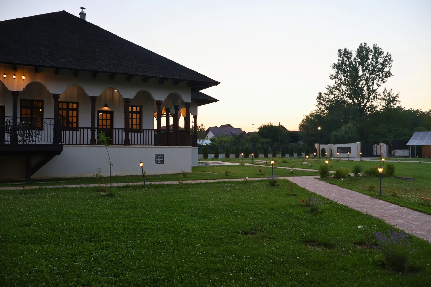 Conac cu cerdac, fotografiat seara, cu aleea luminată
